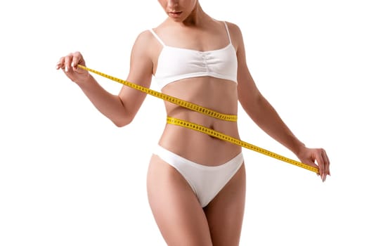 Woman measuring her slim body isolated on white background. Diet. Sport. Health plastic surgery