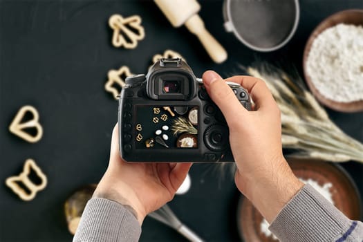 Digital single-lens reflex camera in hands. Photographer shooting hands close up. Man photographer makes photos for stock photography. Male hands hold the camera close-up