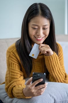 Happy smart young woman Asian using smartphone for shopping, mobile shopping, beautiful woman doing online purchases, shopping online. High quality photo