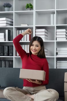 Happy young online business shop owner feeling excited about her sale record in recent month in working room.