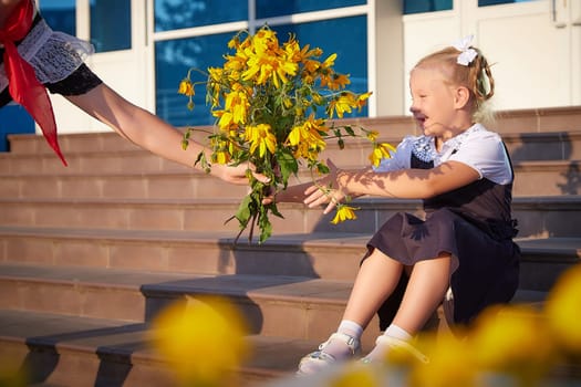 Young and adult schoolgirl on September 1 with flowers. Generations of schoolchildren of USSR and Russia. Female pioneer in red tie and October girl in modern uniform. Daughter and Mother having fun