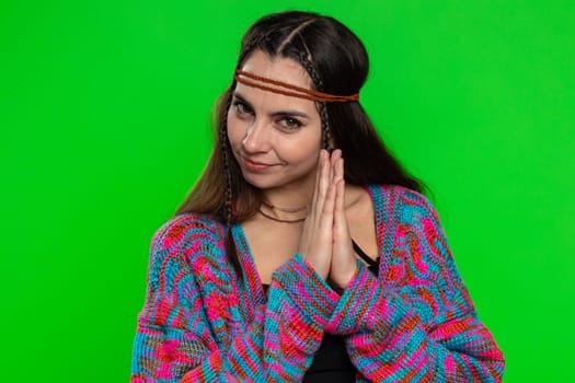 Sneaky cunning young hippie woman with tricky face gesticulating and scheming evil plan, thinking over devious villain idea, cunning cheats, jokes, pranks. Girl isolated on green chroma key background