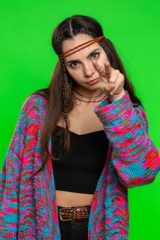 I am watching you. Young confident woman pointing at her eyes and camera, show I am watching you gesture, spying on someone. Pretty hippie girl isolated alone on chroma key background, green screen