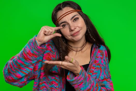 Need some more, please give me. Woman showing a little bit gesture with sceptic smile, showing minimum sign measuring small size. Hippie girl isolated alone on chroma key background, green screen