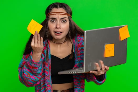 Exhausted freelancer woman with pasted sticker notes use laptop computer having concentration problem creative crisis. Nervous girl confused by big routine work loading on green chroma key background