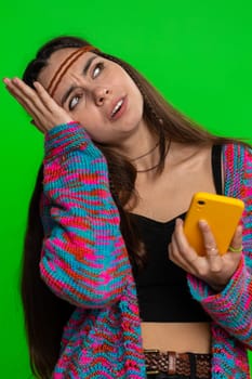 Woman use mobile phone smartphone typing browsing, loses becoming surprised sudden lottery results, bad fortune, loss, fail. Pretty hippie girl isolated on chroma key background, green screen, indoors