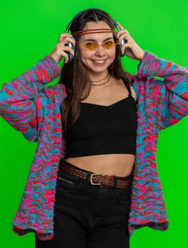 Happy woman in headphones listening music and dancing disco fooling around having fun expressive gesticulating hands, relaxing on party. Girl in sunglasses isolated on studio chroma key background