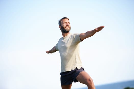 Yoga - an exercise that invigorates you. a handsome mature man doing yoga outdoors