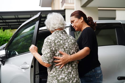 Caregiver help Asian elderly woman disability patient get in her car, medical concept.