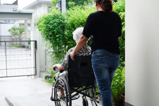 Caregiver help Asian elderly woman disability patient sitting on wheelchair in hospital, medical concept.