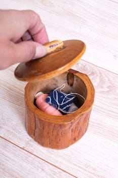 Wooden box with threads and needles close up