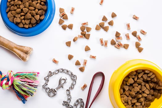 Collar, blue bowl with feed, leash and delicacy for dogs. Isolated on white background. Top view. Still life. Copy space
