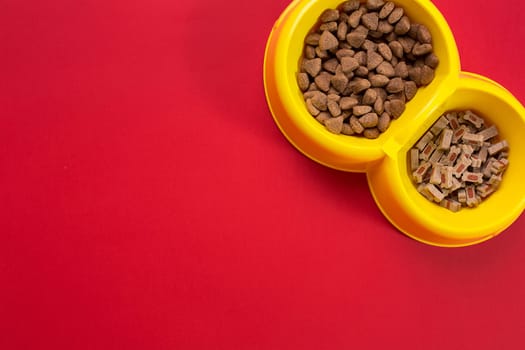 dry pet food in bowl on red background top view. Still life. Copy space