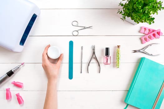 Woman Hands Care. Top View Of Beautiful Smooth Woman's Hands With Professional Nail Care Tools For Manicure On White Background. Close up. Top view. Copy space