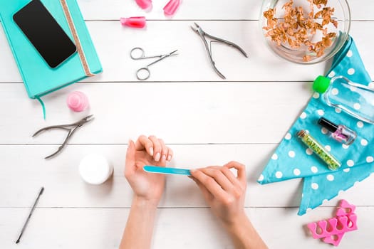 Woman Hands Care. Top View Of Beautiful Smooth Woman's Hands With Professional Nail Care Tools For Manicure On White Background. Close up. Top view. Copy space