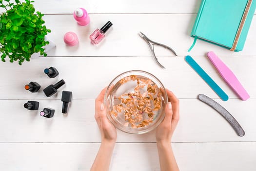 Woman Hands Care. Top View Of Beautiful Smooth Woman's Hands With Professional Nail Care Tools For Manicure On White Background. Close up. Top view. Copy space