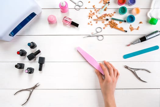 Manicure set and nail polish on wooden background. Top view. Copy space. Still life. Nail Care.