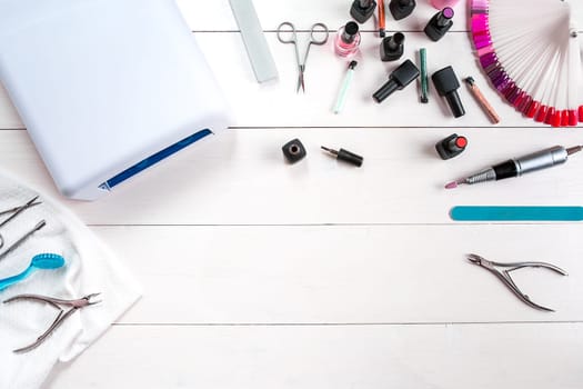 Manicure set and nail polish on wooden background. Close up. Top view. Copy space