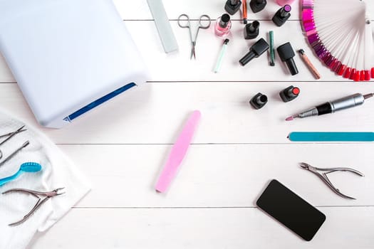 Manicure set and nail polish on wooden background. Close up. Top view. Copy space