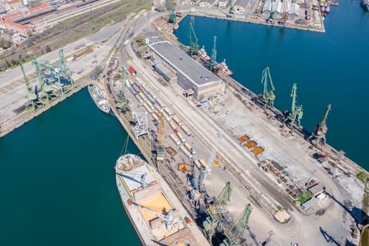 13 April 2023 Black sea port Varna, Bulgaria: Traffic jam made of ukranian grain trucks waiting in line for unloading in the port harbor, top view from a drone on trucks loaded with grain.