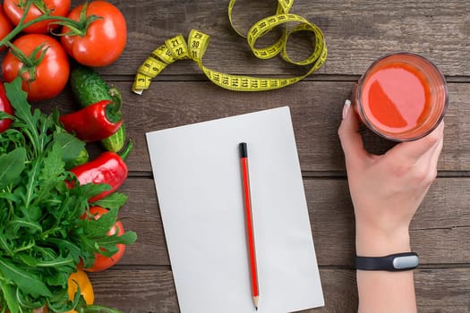 Sport and diet. Vegetables, a glass of tomato juice and centimeter. Peppers, tomatoes, salad on rustic background. Top view. Copy space