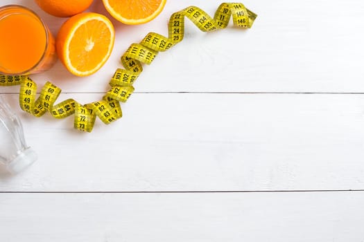 Fitness concept with fruit, bowl of oatmeal and centimeter. Top view background concept. Copy space