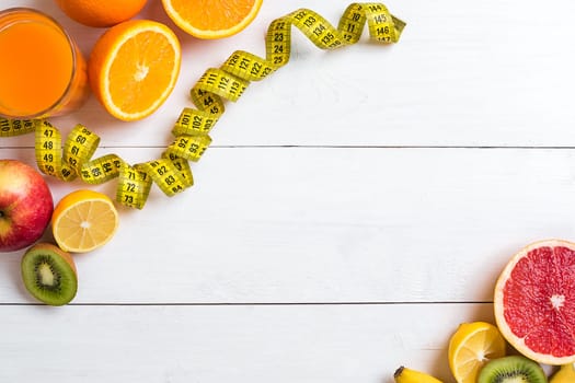 Fitness concept with fruit, bowl of oatmeal and centimeter. Top view background concept. Copy space
