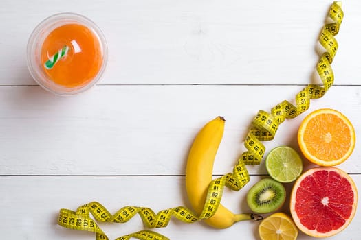 Fitness concept with fruit, bowl of oatmeal and centimeter. Top view background concept. Copy space