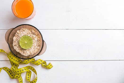 Breakfast with oatmeal and juice on white background. Top view. Copy space Flat lay