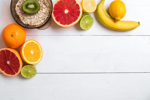Fresh fruits with tape measure over white wooden background. Fitness concept. Top view. Copy space Flat lay