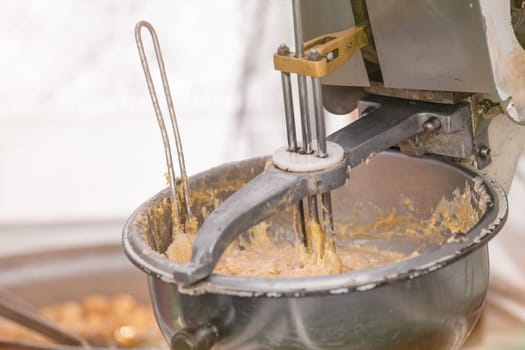 The process of making fresh cookies. Large industrial mixer close-up. She mixes the dough for sweet pastries in a pastry shop. High quality photo