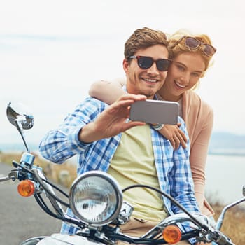 Making memories with you is my favourite thing to do. a couple taking a selfie while out on a road trip with a scooter