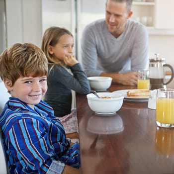 I love my family. Portrait of a young boy having breakfast together with his family at home