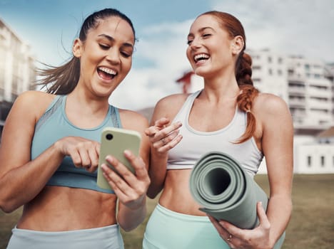 Yoga, fitness and phone with woman friends laughing at a meme in the park together during exercise. Pilates, social media and training with a female and friend joking outside on a field for a workout.