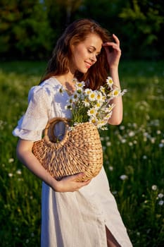 portrait of a beautiful red-haired girl in a flowering field, straightening her hair. High quality photo