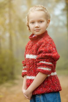 Image of pretty little girl posing in red sweater, close-up