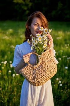 portrait of a beautiful, happy red-haired woman holding a basket of daisies in her hands. High quality photo