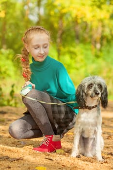 Image of adorable little girl posing with dog outdoors