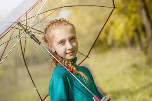 Smiling freckled girl posing with umbrella, close-up