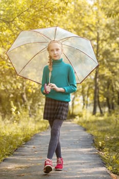 Image of adorable little girl posing with umbrella in park