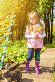 Image of pretty little girl walking with cute rabbit