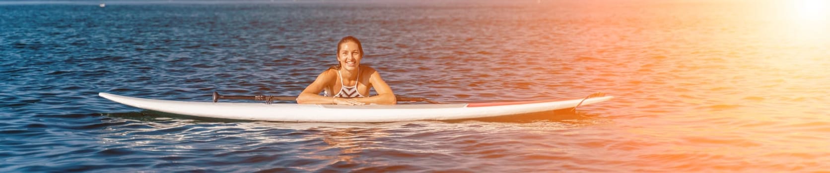 Woman summer surfing on the beach: A sporty girl in a striped swimsuit rides the waves on a surfboard on a sunny summer day at the beach, enjoying the fun and excitement of surfing