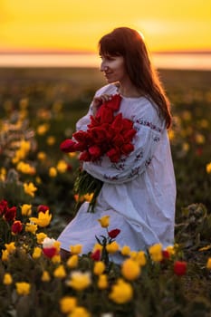 Woman field tulips sunset. Woman against sunset and wild tulip flowers, natural seasonal background. Multi-colored tulips Tulipa schrenkii in their natural habitat are listed in the Red Book