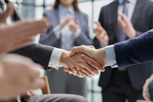 businessmen shaking hands starting teamwork partnership standing in corporate work space hallway