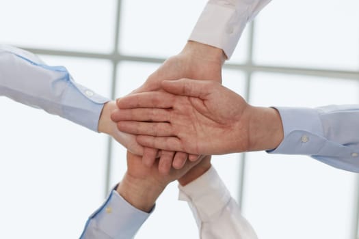 Cropped topview of businesspeople putting their hands. Conception of successful teambuilding