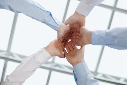 Cropped topview of businesspeople putting their hands. Conception of successful teambuilding