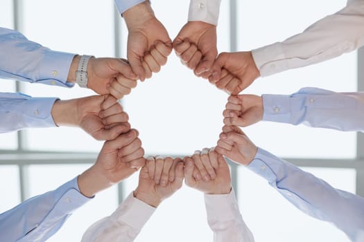 A group of successful businesspeople making fist bump together to cheer up, support and making a team spirit in the meeting