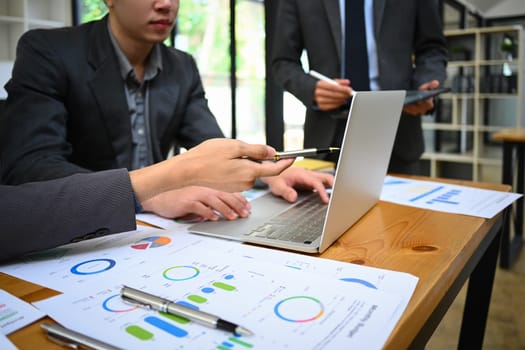 Business team working with reports and analyzing statistics data online on laptop screen.