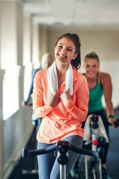 Just give me a bike and Im good to go. a young woman working out with an exercise bike in a spinning class at the gym