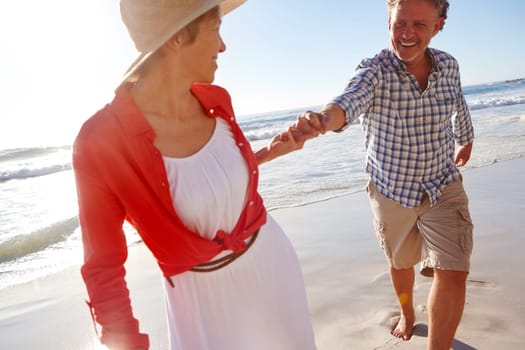 Holding hands forever. a mature couple enjoying a late afternoon walk on the beach